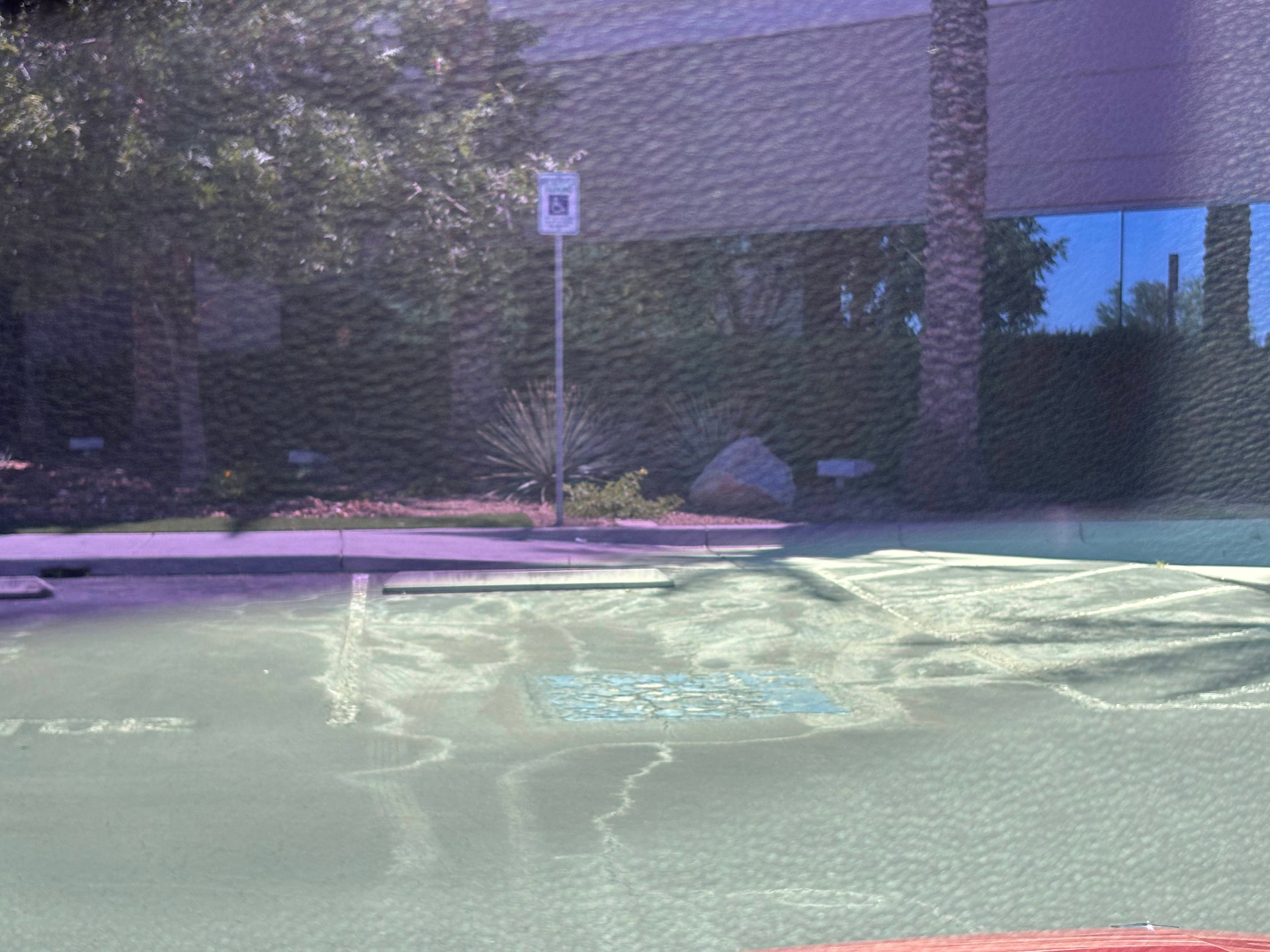 Sun bleached accessible parking stall with signage at a commercial building