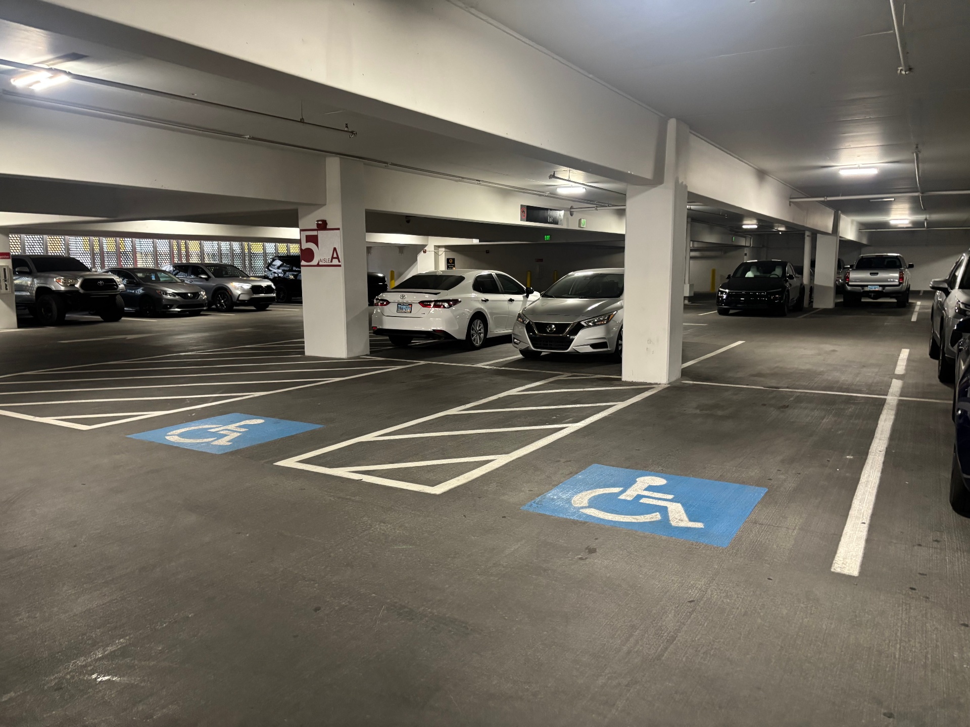 Two clearly painted blue accessibility symbols in a covered parking garage