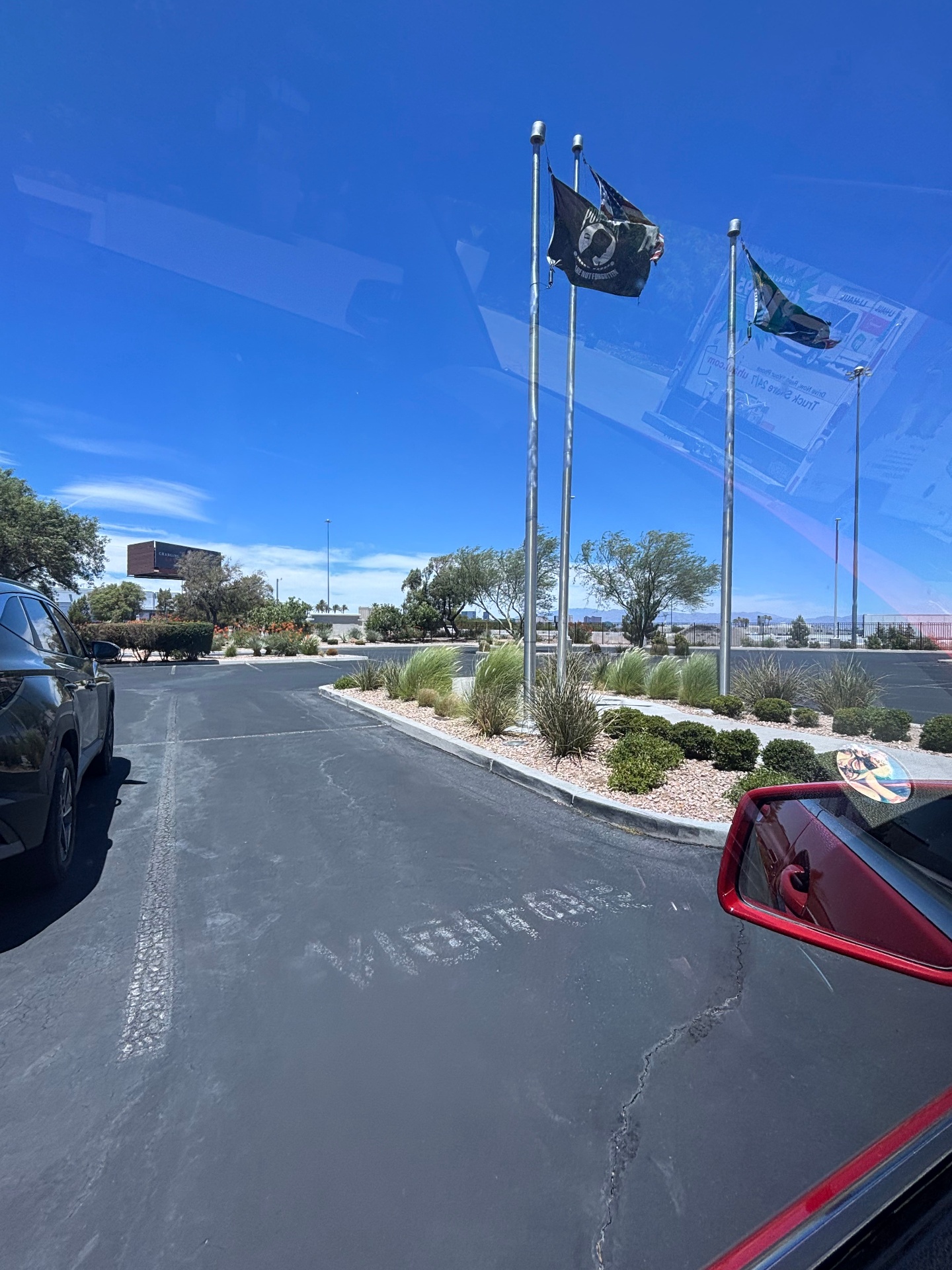 Commercial parking lot with flagpoles and faded visitor markings